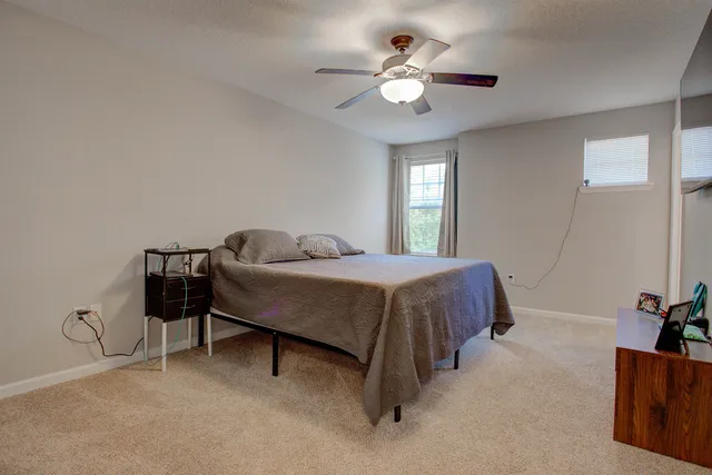 a spacious bedroom with a bed and a chandelier