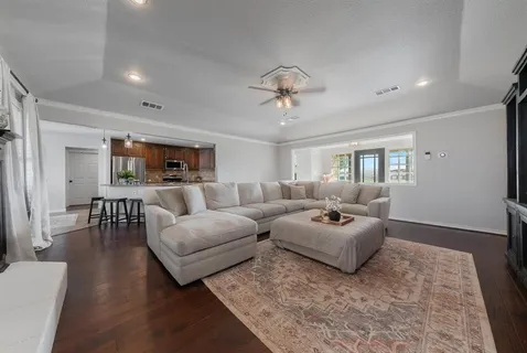 a living room with furniture and a wooden floor