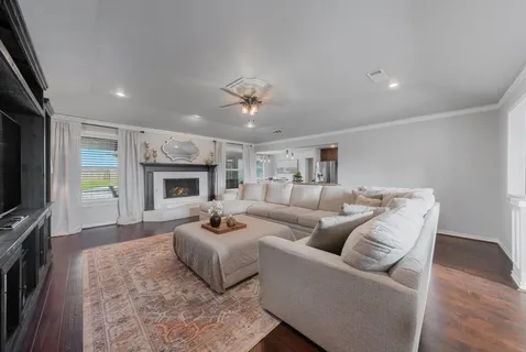 a living room with furniture a fireplace and a flat screen tv