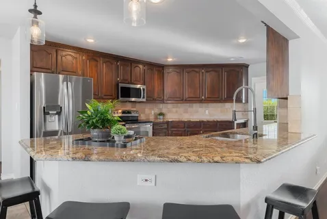 a kitchen with granite countertop kitchen island cabinets and stainless steel appliances