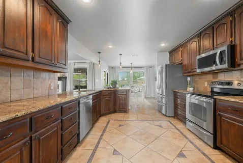 a large kitchen with stainless steel appliances lots of counter top space