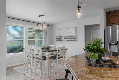 a dining room with furniture potted plants and wooden floor
