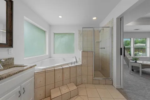 a bathroom with a granite countertop sink a mirror and a shower