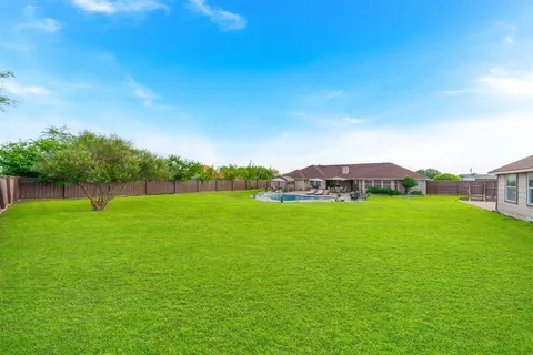 a view of a green field with wooden fence