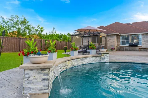 a view of a house with pool and sitting area