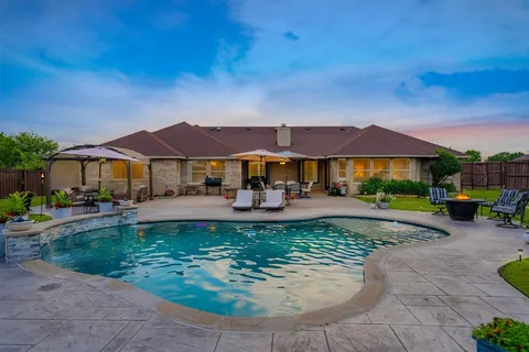a view of a house with swimming pool and a yard