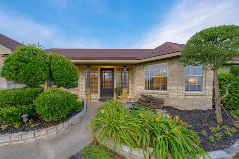 a front view of a house with a garden