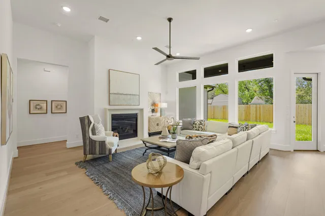 a living room with furniture a fireplace and a chandelier