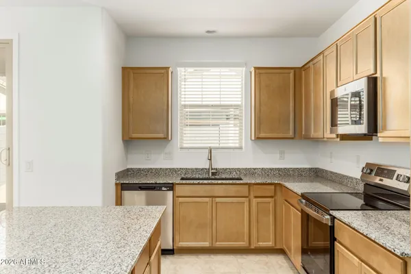 a kitchen with granite countertop a sink stove and cabinets