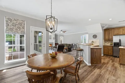 a view of a dining room with furniture a chandelier and wooden floor