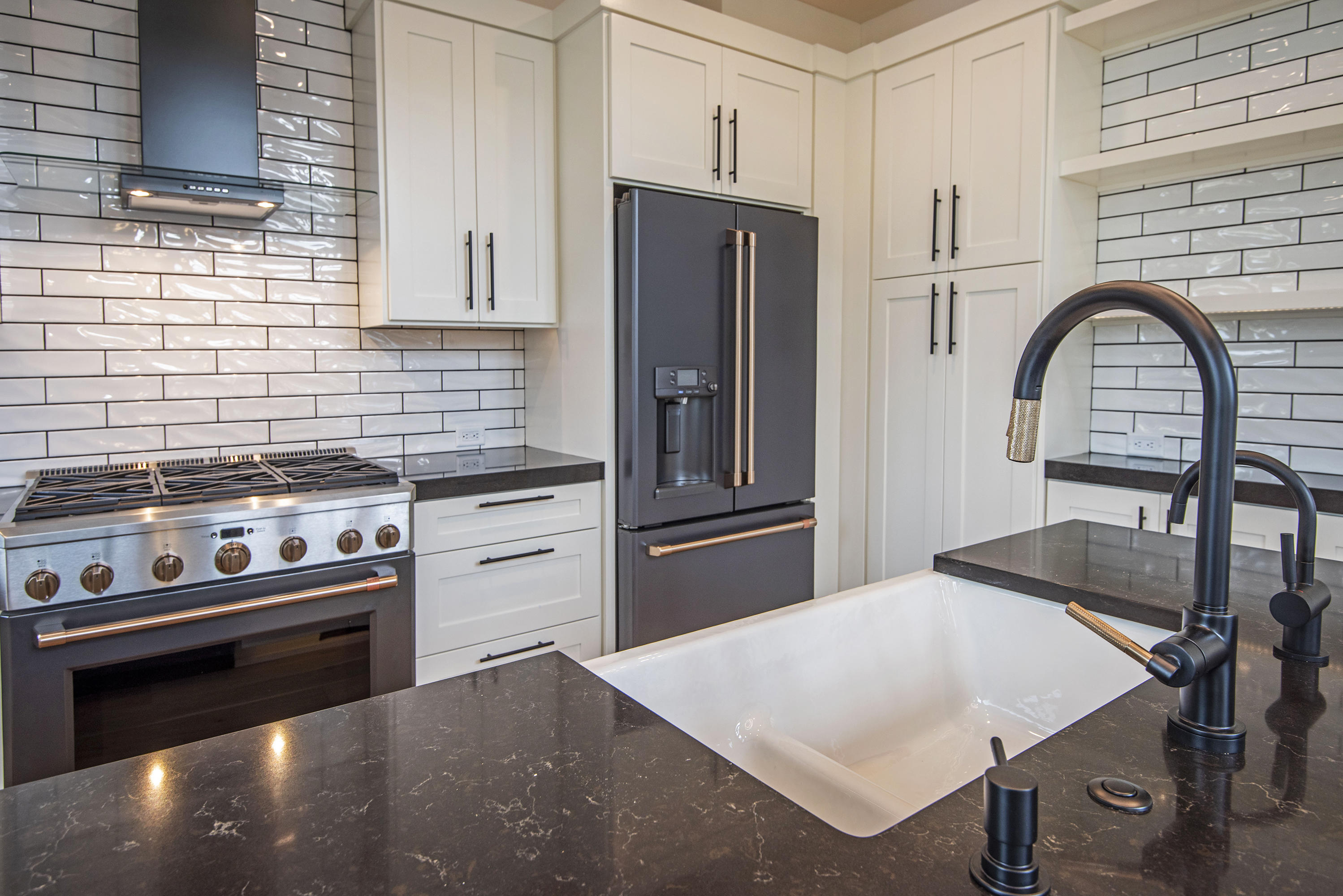 404 Northwest Riverside Boulevard Bend, OR 97703 - Photo 9 of 25 Six-burner stove and stacked subway tiles. Porcelain sink with high-end fixtures.