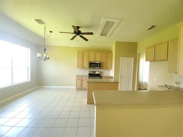 a view of a kitchen with kitchen island a sink stainless steel appliances and cabinets