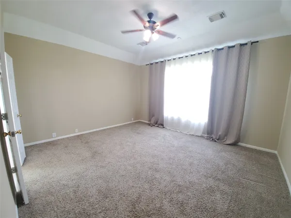 a view of empty room with a ceiling fan and window