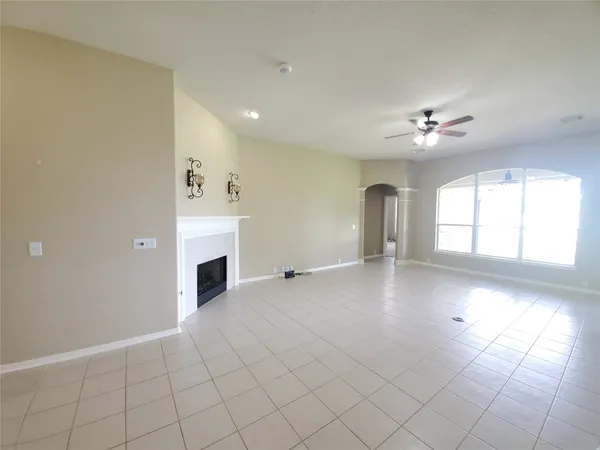 an empty room with windows and fireplace