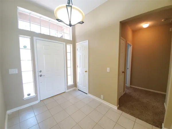a view of a chandelier fan and entryway