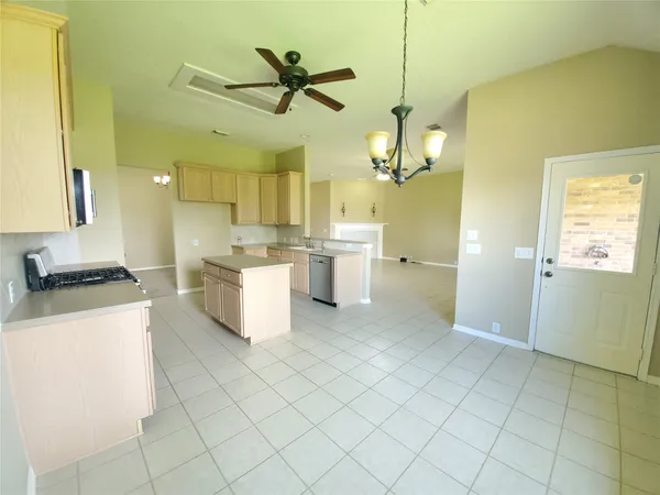 a kitchen with a stove a refrigerator and white cabinets