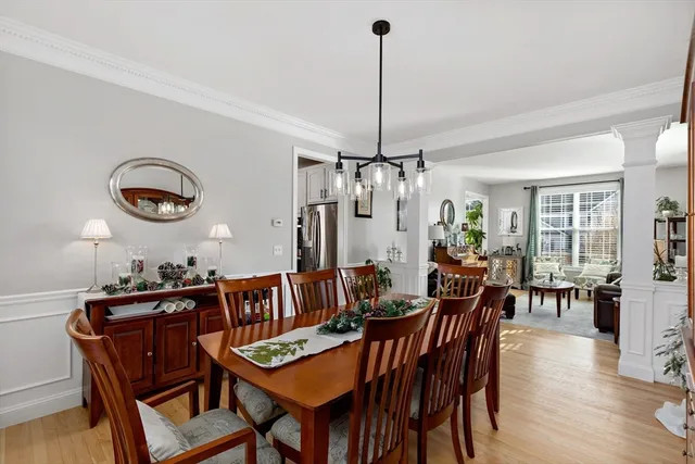 a view of a dining room and livingroom with furniture wooden floor a chandelier