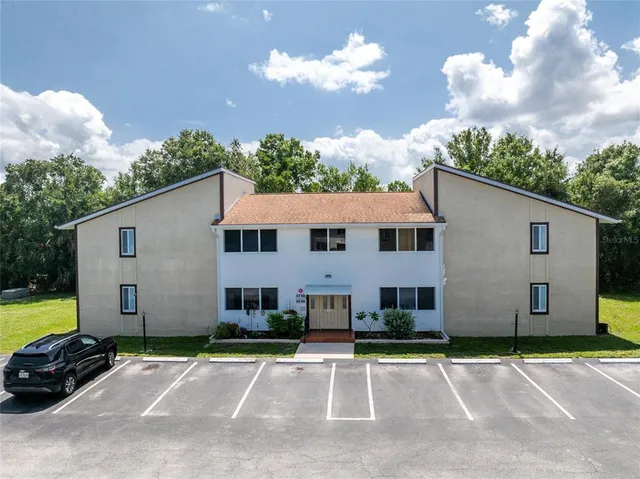 a view of a white house with a yard and a garage
