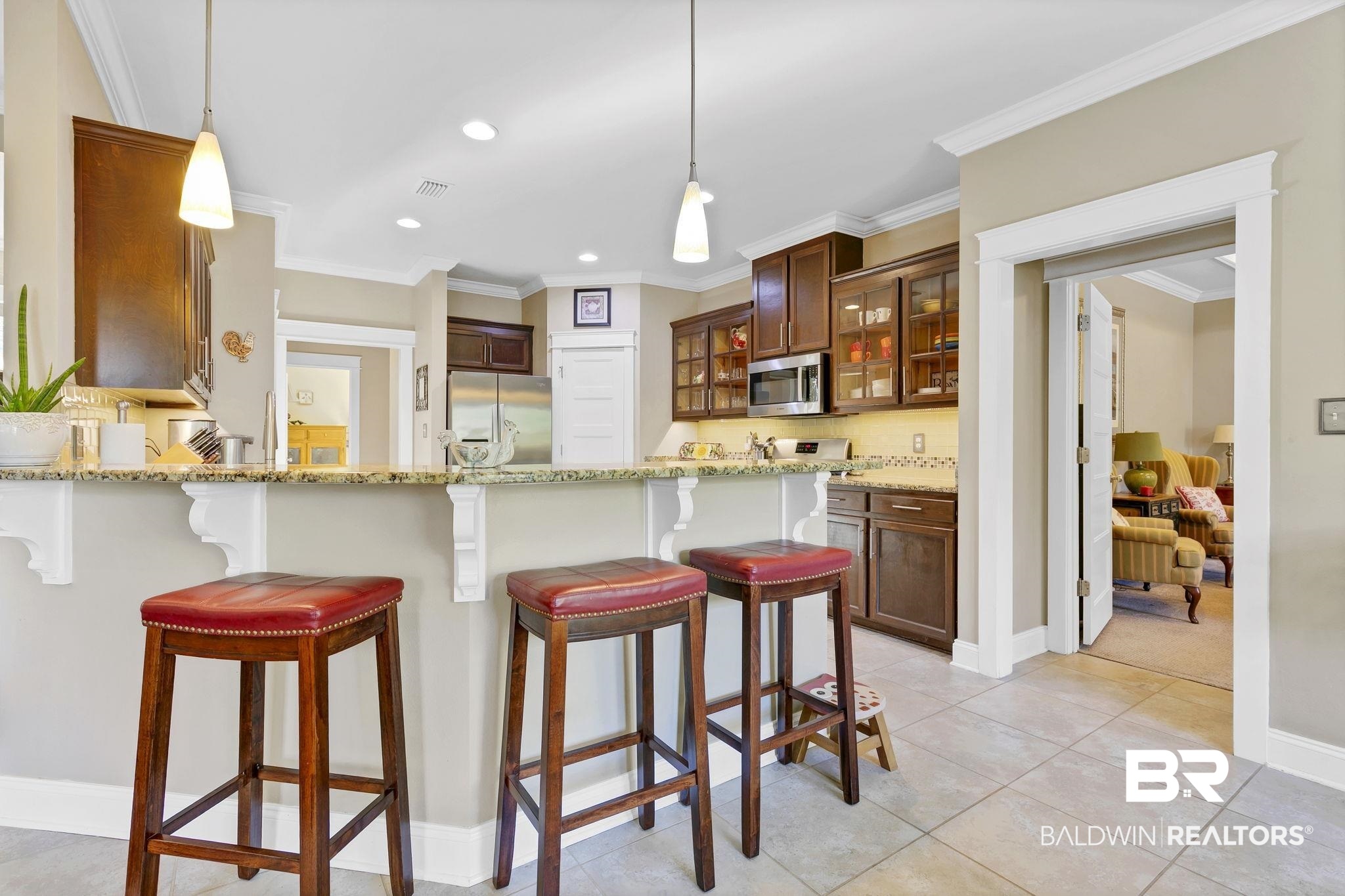 20105 Bunker Loop Fairhope, AL 36532 - Photo 23 of 65 Kitchen with a kitchen breakfast bar, appliances with stainless steel finishes, glass insert cabinets, and a peninsula