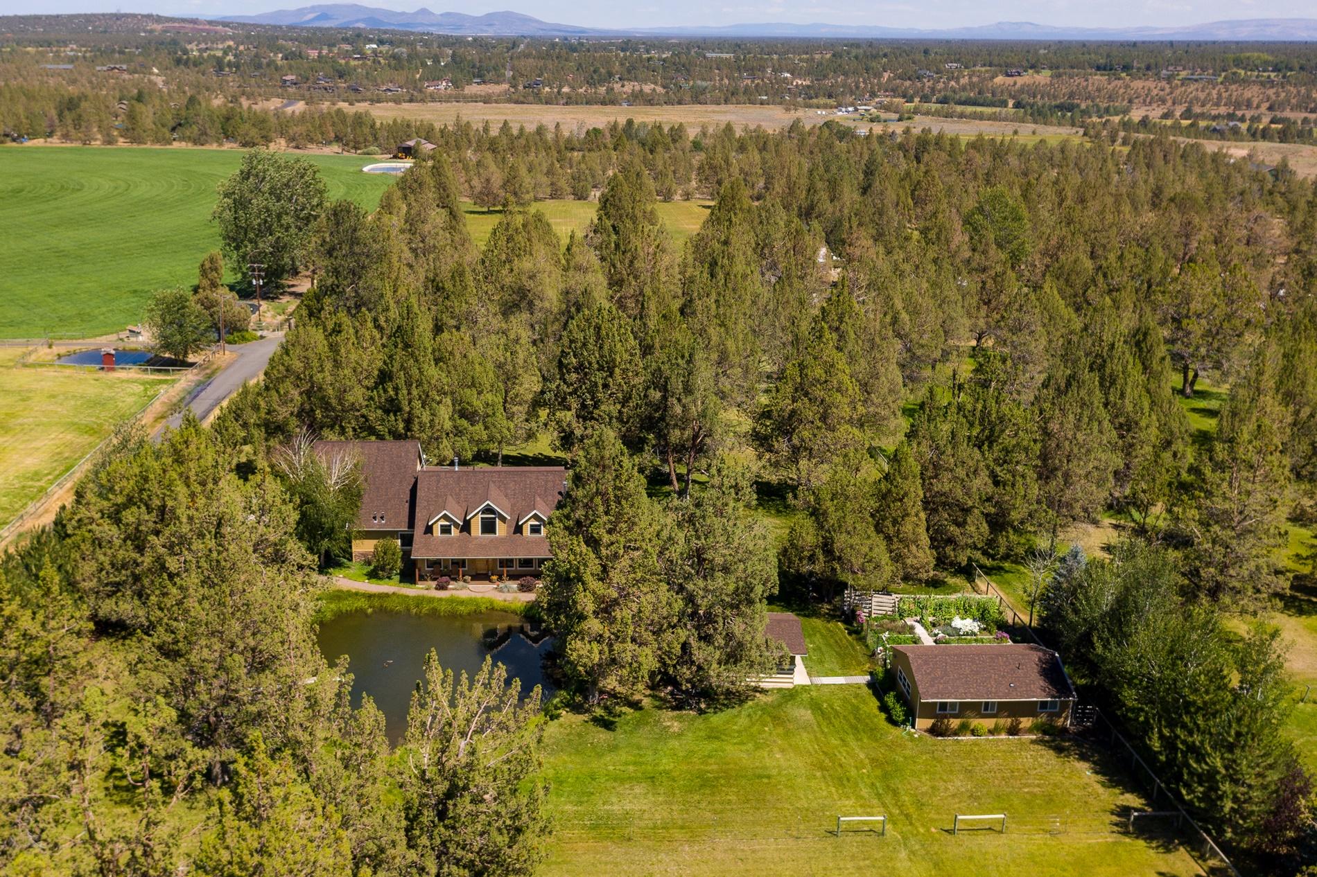 64980 Gerking Market Road Bend, OR 97703 - Photo 25 of 35 This aerial view is from the West looking down on the main home, garden/hay area, and studio to the right.
