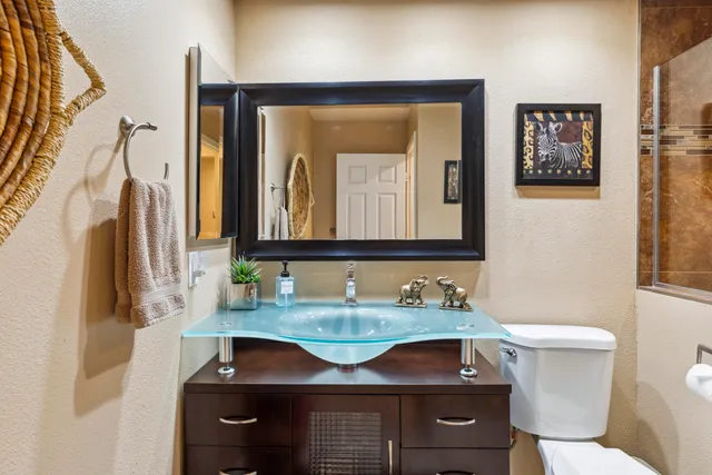 a bathroom with a sink a toilet and mirror