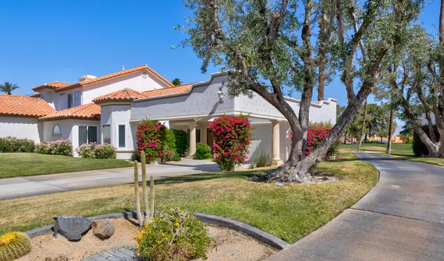 a view of a house with a fountain and a tree