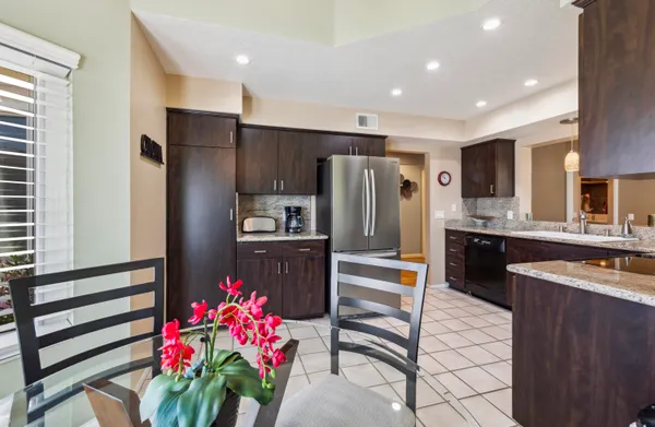 a kitchen with granite countertop a refrigerator and a sink