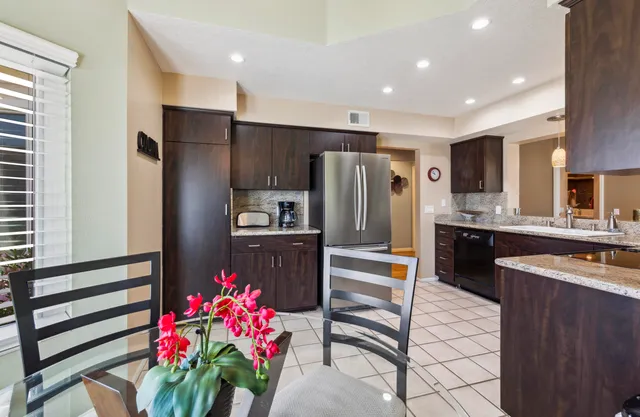 a kitchen with granite countertop a refrigerator and a sink