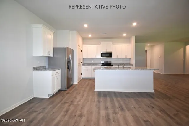 a kitchen with stainless steel appliances a refrigerator sink and white cabinets