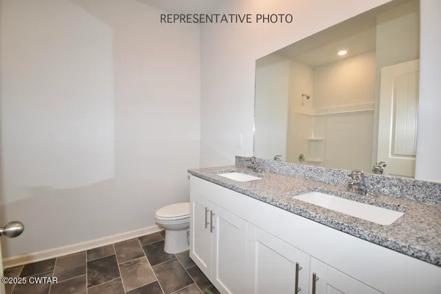 a bathroom with a granite countertop sink a toilet and a mirror