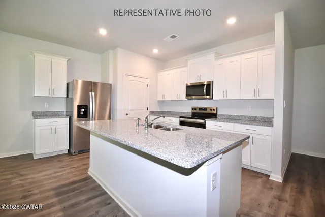 a kitchen with stainless steel appliances granite countertop a sink refrigerator and microwave