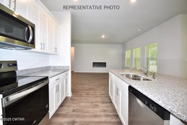 a kitchen with stainless steel appliances granite countertop a sink stove and microwave
