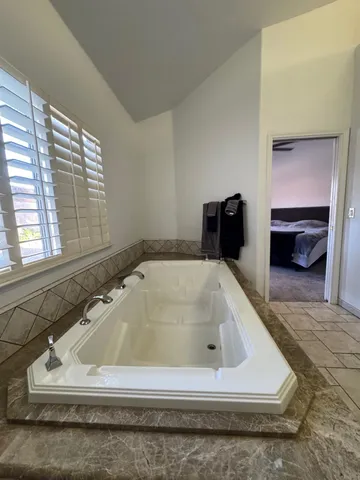 a spacious bathroom with a granite countertop sink and a mirror