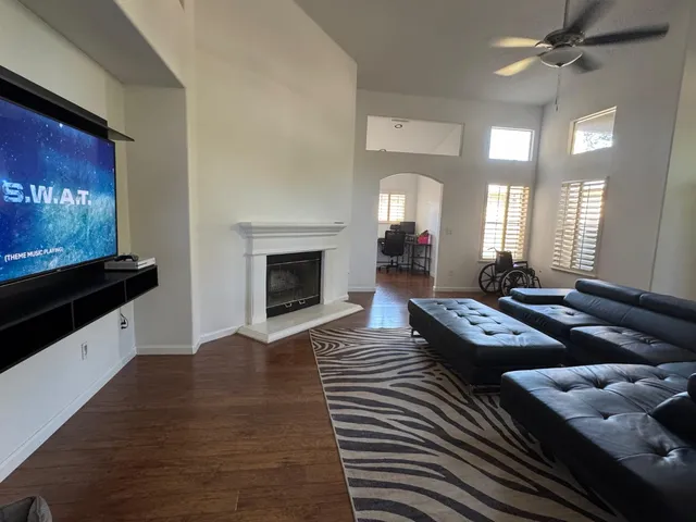 a living room with lots of furniture and a ceiling fan