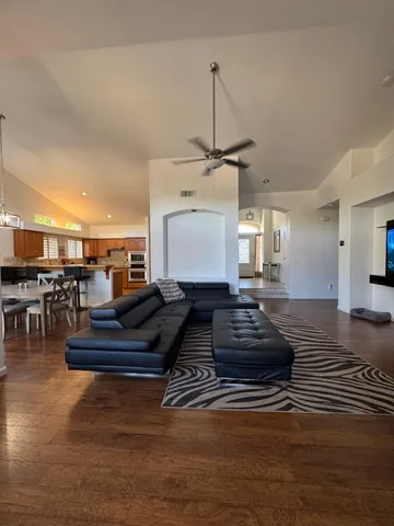 a kitchen with kitchen island granite countertop wooden floors and view living room