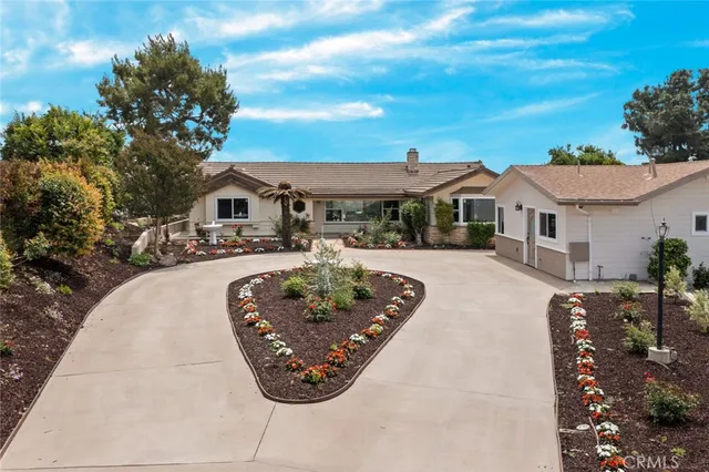 a view of a white house with a swimming pool and a yard