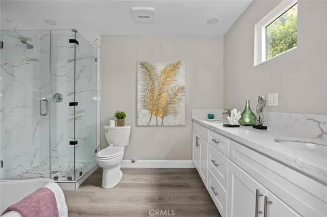 a spacious bathroom with a granite countertop toilet a sink and a shower