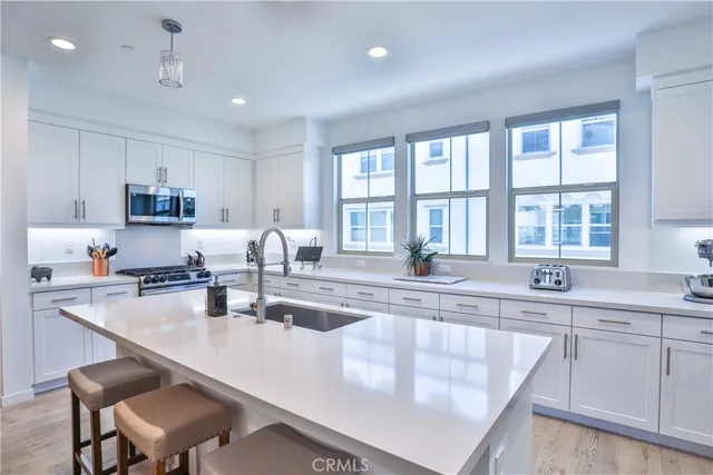 a large kitchen with kitchen island granite countertop a sink a stove and cabinets