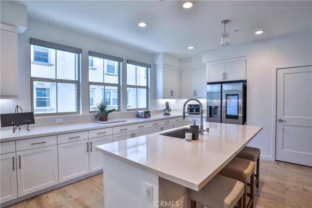 a kitchen with a sink a counter space appliances and cabinets