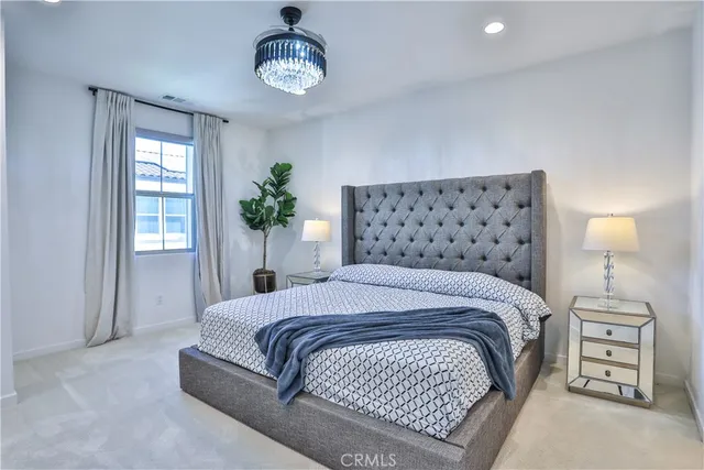 a bedroom with a large bed and a chandelier