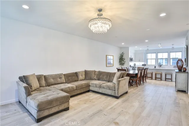 a living room with furniture and a dining table with kitchen view