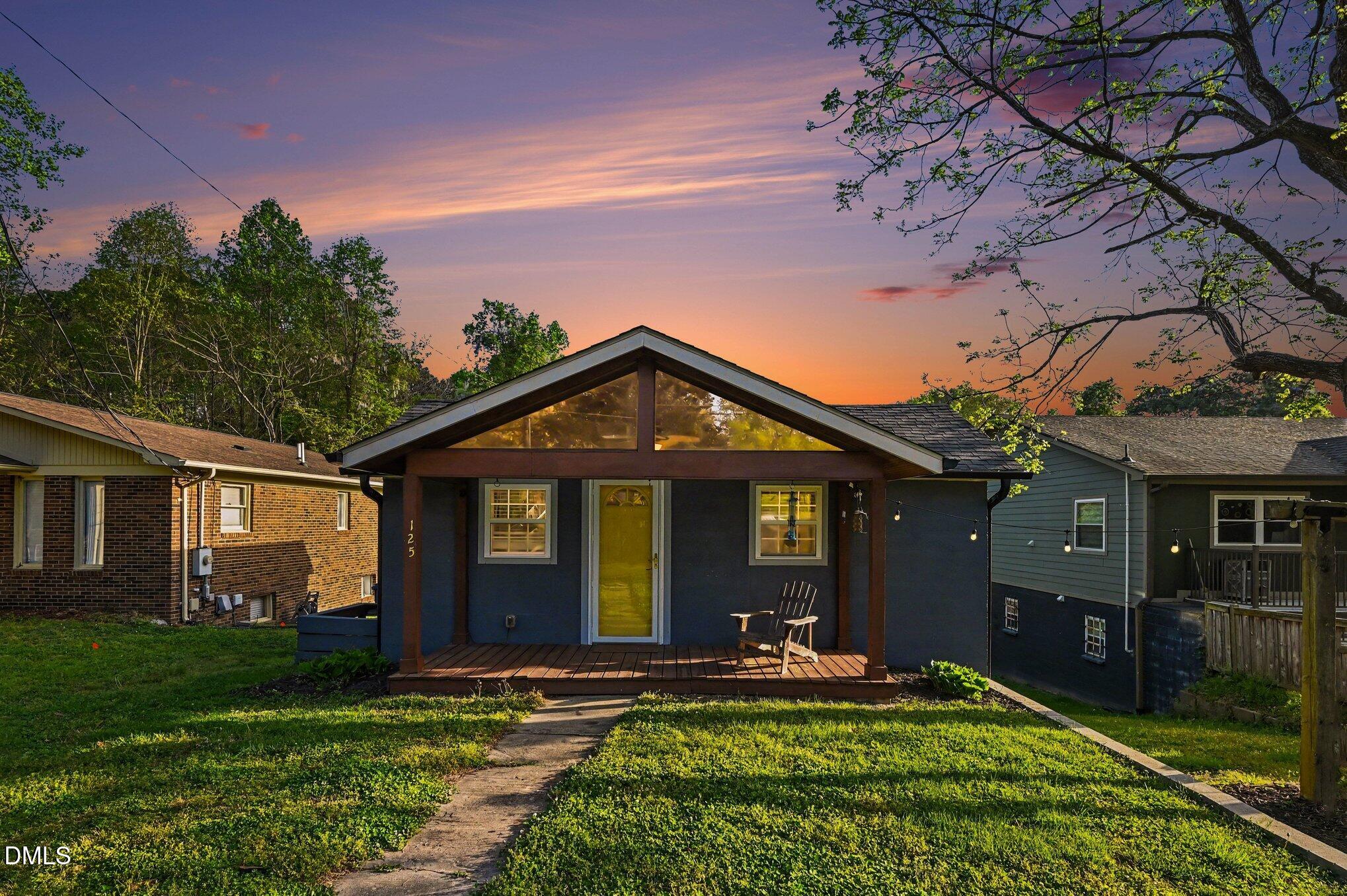 a front view of a house with yard and green space