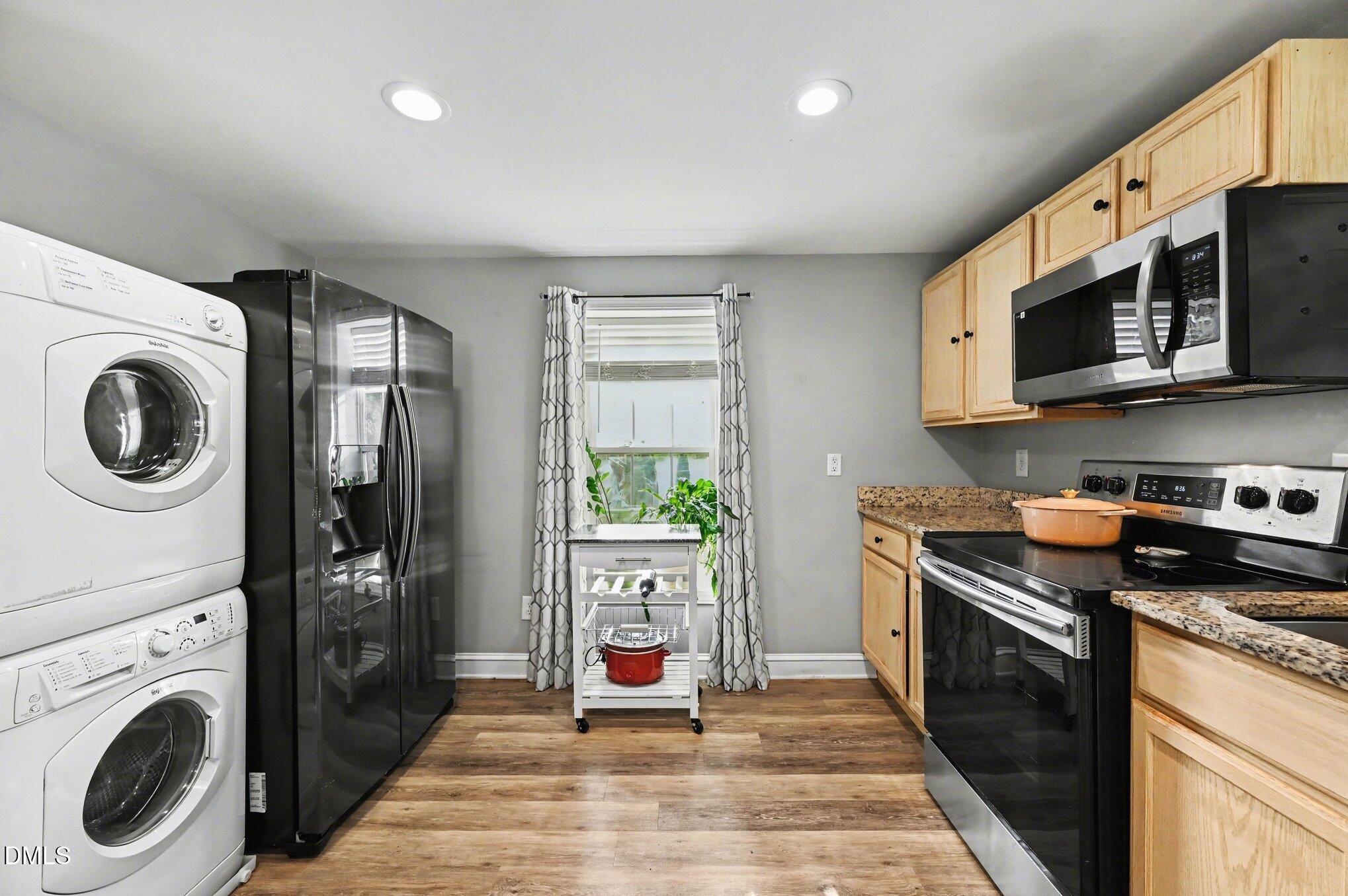 125 Barnhill Street Durham, NC 27707 - Photo 10 of 27 a large kitchen with stainless steel appliances granite countertop a stove a microwave and a view of living room