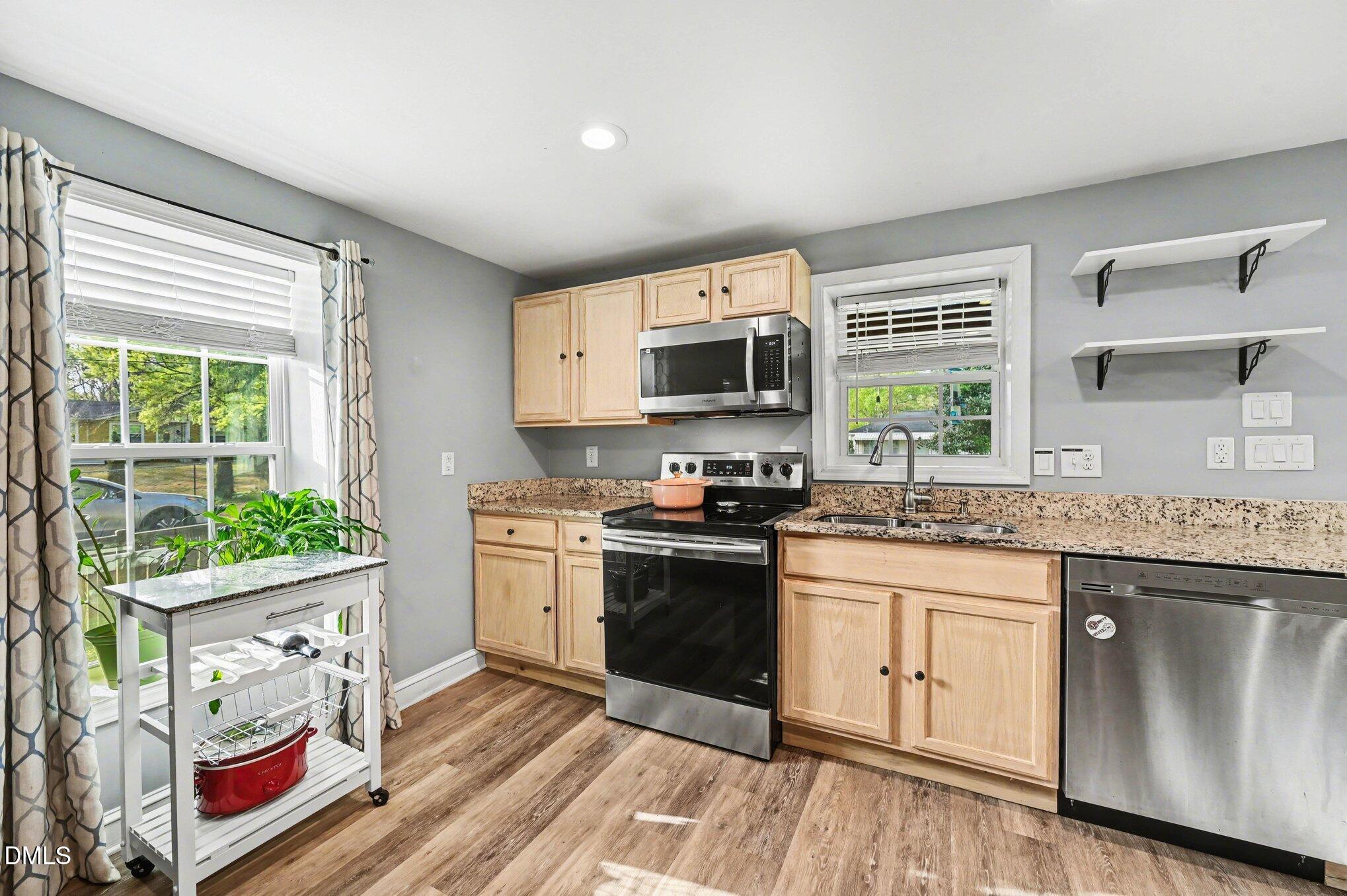 125 Barnhill Street Durham, NC 27707 - Photo 11 of 27 a kitchen with stainless steel appliances granite countertop a stove a sink and a microwave