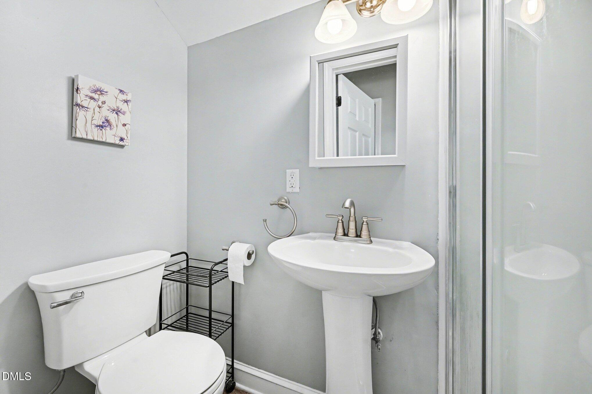 125 Barnhill Street Durham, NC 27707 - Photo 18 of 27 a bathroom with a toilet a sink and mirror