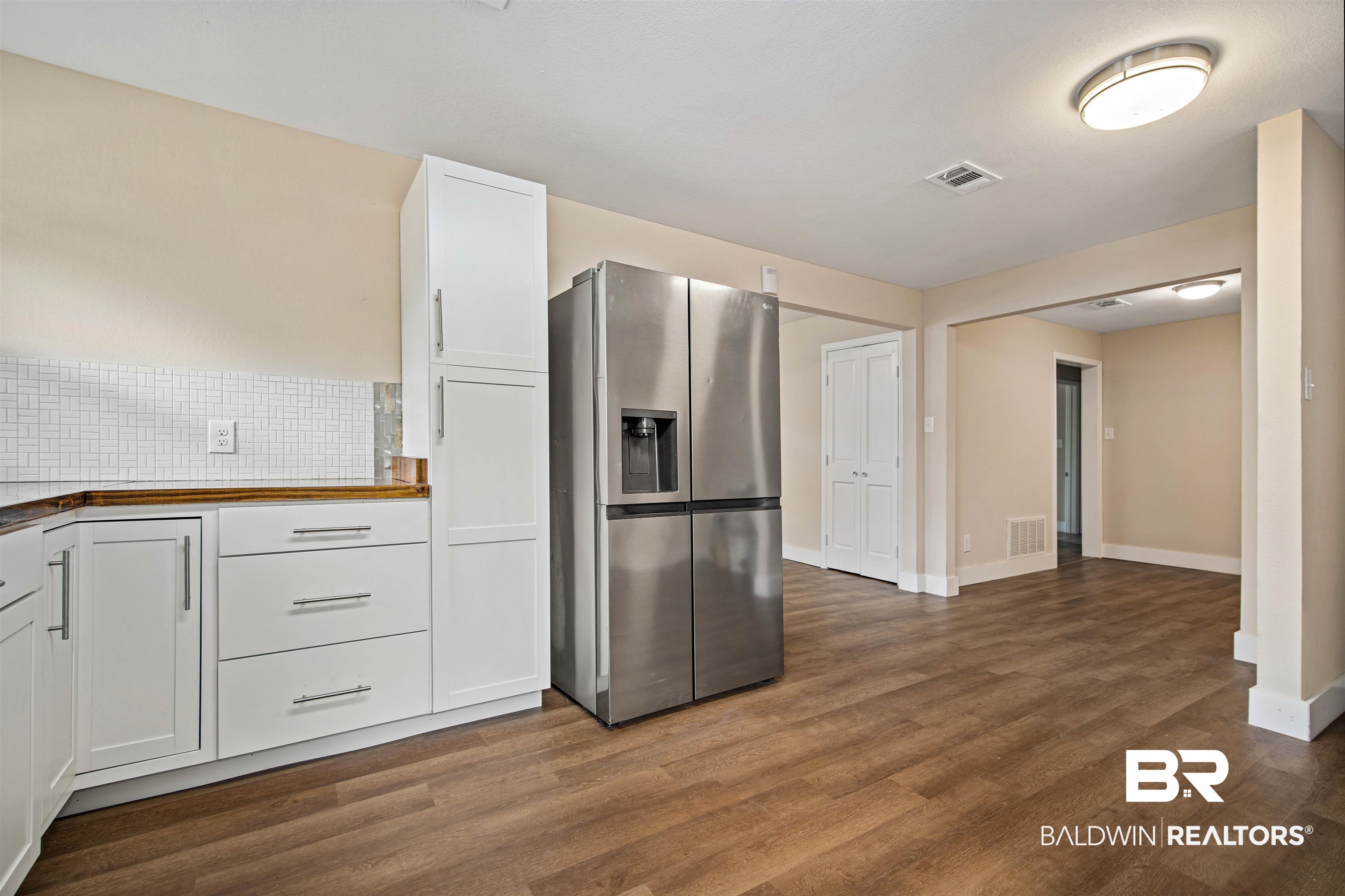 2119 Autrey Avenue Eight Mile, AL 36613 - Photo 9 of 22 Kitchen featuring butcher block counters, white cabinets, dark hardwood / wood-style flooring, and stainless steel fridge with ice dispenser