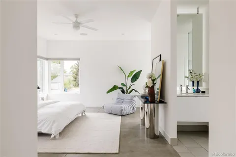 a white bed sitting in a bedroom next to a window