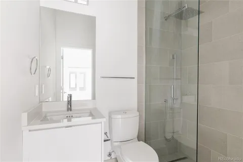 a bathroom with a toilet sink vanity and shower