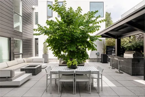 a view of a patio with a table and chairs and potted plants