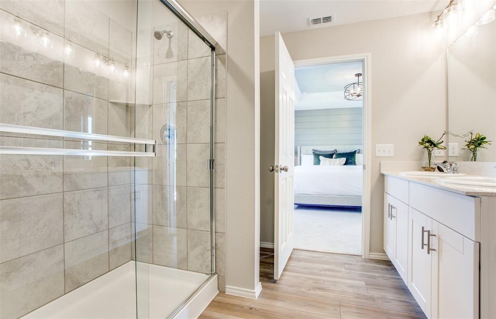 313 Hopson Street Van Alstyne, TX 75495 - Photo 14 of 16 a en suite spacious bathroom with a double vanity sink a mirror and shower